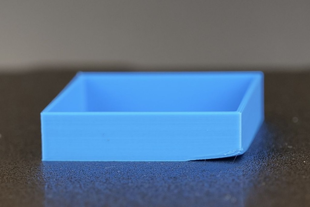 Warping: Blaue 3D-Druck-Box mit abgehobener Ecke vom Druckbett