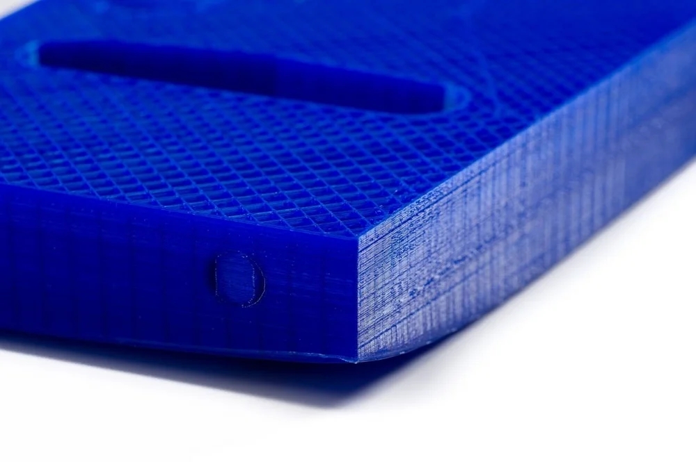 Warping: Nahaufnahme der abgehobenen Ecke eines blauen 3D-Drucks